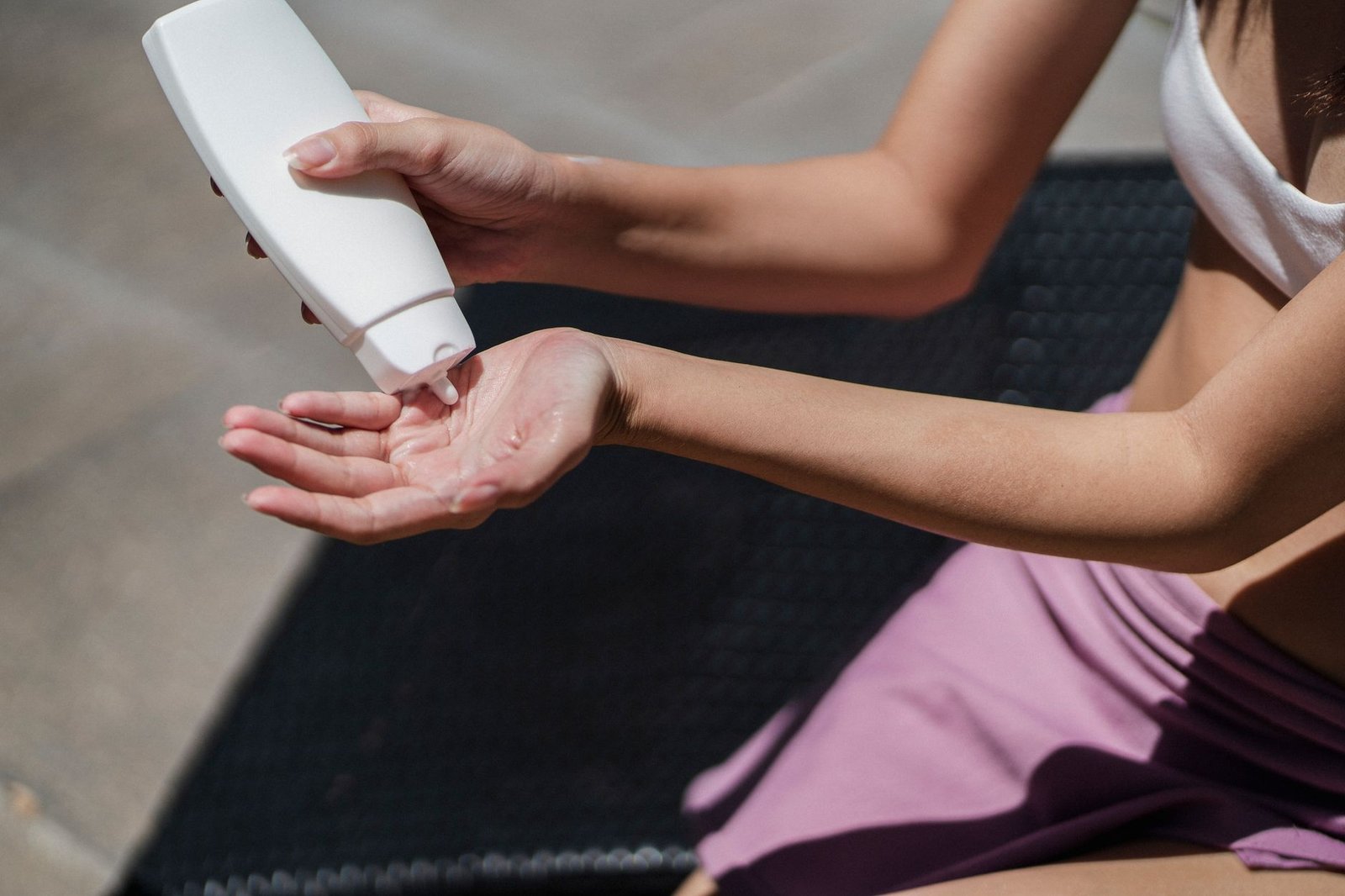 Applying non-comedogenic sunscreen at the poolside, a daily habit that supports acne treatment in the Maldives
